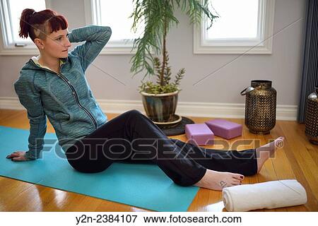 Young woman reclining on a yoga mat after a workout in a studio. View Large Photo Image Stock Photo - Young woman reclining on a yoga mat after a workout in a studio.. Fotosearch