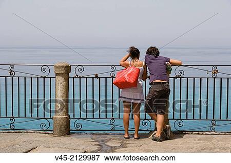 A couple enjoying the view from the terrace of Corso Vittorio Emmanuele, Tropea, Vibo Valentia, Calabria, Southern Italy, Italy. View Large Photo Image Stock Photo - A couple enjoying the view from the terrace of Corso Vittorio Emmanuele, Tropea, Vibo Valentia, Calabria, Southern Italy, Italy.. Fotosearch