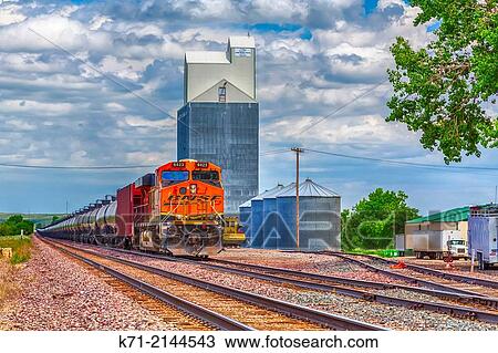 A farm grain elevator and freight train in Brockton, Montana, USA. View Large Photo Image Stock Image - A farm grain elevator and freight train in Brockton, Montana, USA.. Fotosearch