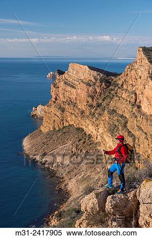A men looks out over the Mediterranean sea from Sierra Helada natural park cliff, Benidorm, Alicante province, Spain. View Large Photo Image Stock Photography - A men looks out over the Mediterranean sea from Sierra Helada natural park cliff, Benidorm, Alicante province, Spain.. Fotosearch