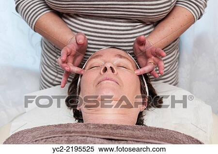Stock Photography - A woman in her early sixties having a facial and make up beauty treatment by a beauty therapist.. Fotosearch