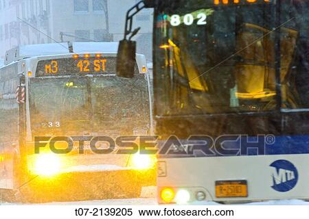 Stock Photography - Afternoon rush hour traffic, Mass Transit, MTA M3 Public Transportation Buses, during January 21, 2014 winter storm, Midtown Manhattan, 59th Street vicinity, via 5th Avenue, New York City, USA.. Fotosearch