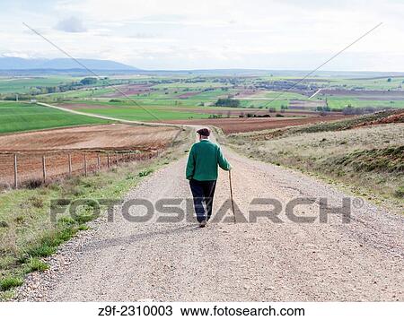 Stock Image - An old man walks down a path of Sotillo, Sepulveda, Segovia, Spain.. Fotosearch