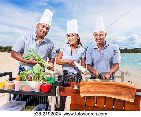 Picture - Asian catering chefs at the beach cooking with a Koththu station. Gold Coast, Queensland, Australia.. Fotosearch
