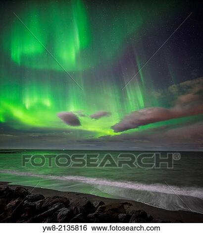Aurora Borealis or Northern lights over waves breakiing on the beach in Seltjarnarnes, Reykjavik, Iceland. View Large Photo Image Stock Photograph - Aurora Borealis or Northern lights over waves breakiing on the beach in Seltjarnarnes, Reykjavik, Iceland.. Fotosearch