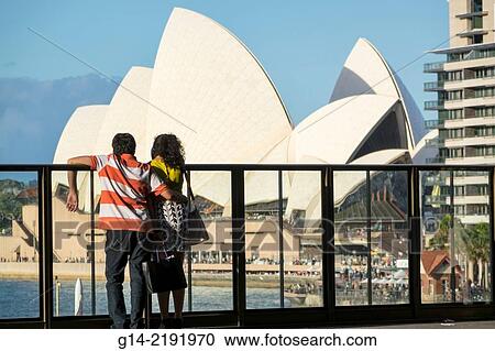 Stock Image - Australia, NSW, New South Wales, Sydney, Sydney Harbour, harbor, Opera House, Circular Quay, man, woman, couple, looking.. Fotosearch
