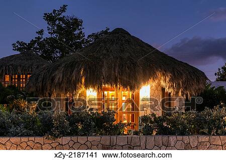 Boutique hotel cottages with thatched roof at night, Negril, Jamaica. View Large Photo Image Stock Image - Boutique hotel cottages with thatched roof at night, Negril, Jamaica.. Fotosearch