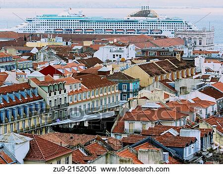 Stock Photography - Cityscape of central Lisbon with giant cruise ship Oceana docking on the waterfront. Seen from viewing platform at top of Elevador de santa Justa, Portugal, western Europe.. Fotosearch