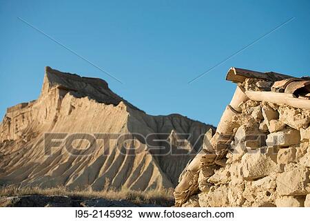 Cliffs eroded by rainfall juxtaposed to ruined traditional cattle shelter on clay-only area of the natural park of Bardenas Reales de Navarra, Navarre, Spain. View Large Photo Image Stock Image - Cliffs eroded by rainfall juxtaposed to ruined traditional cattle shelter on clay-only area of the natural park of Bardenas Reales de Navarra, Navarre, Spain.. Fotosearch
