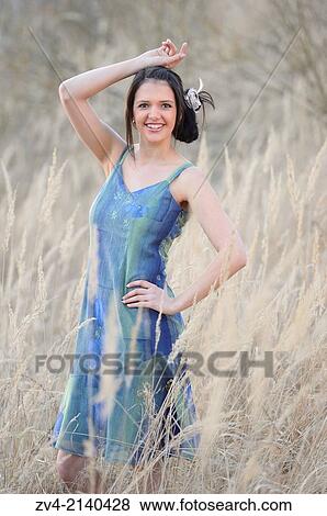 Close-up of a good looking young woman in the grass in early spring. View Large Photo Image Stock Photo - Close-up of a good looking young woman in the grass in early spring.. Fotosearch