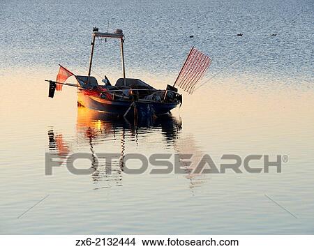 Dawn at Alfacs Bay with small fishing boat. Ebro River Delta Natural Park, Tarragona province, Catalonia, Spain. View Large Photo Image Picture - Dawn at Alfacs Bay with small fishing boat. Ebro River Delta Natural Park, Tarragona province, Catalonia, Spain.. Fotosearch