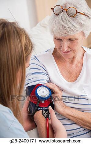 Doctor or nurse testing blood pressure with a blood pressure gage, on a beautiful senior woman at home or in clinic or hospital View Large Photo Image Stock Image - Doctor or nurse testing blood pressure with a blood pressure gage, on a beautiful senior woman at home or in clinic or hospital. Fotosearch