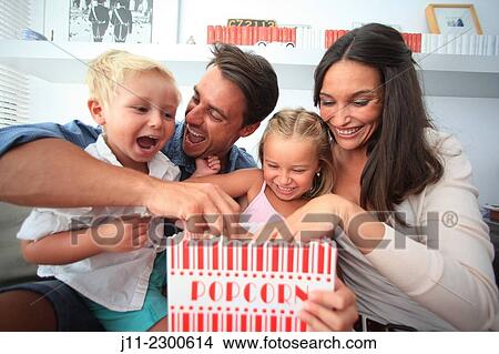 Family fun, eating popcorn View Large Photo Image Picture - Family fun, eating popcorn. Fotosearch