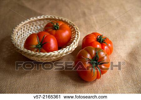 Four tomatoes, two of them in a basket. Still life. View Large Photo Image Stock Image - Four tomatoes, two of them in a basket. Still life.. Fotosearch