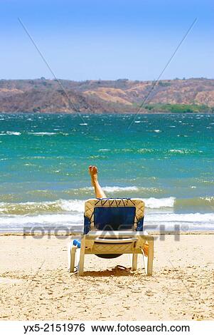 Girl relaxing on a beach chair on the beah. View Large Photo Image Stock Photograph - Girl relaxing on a beach chair on the beah.. Fotosearch