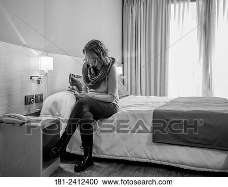 Stock Image - girls watching an agenda Mobile phone in room, Madrid, Spain. Fotosearch
