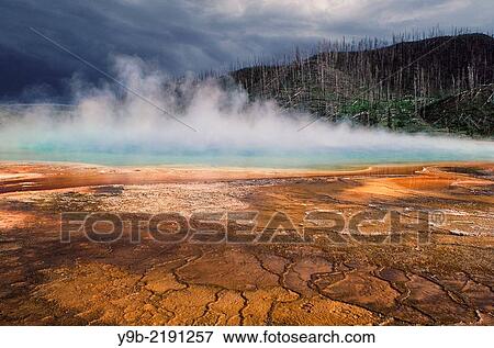 Stock Photo - Grand Prismatic Spring with colorful algae and approaching storm clouds, Midway Geyser Basin, Yellowstone National Park, Wyoming, USA.. Fotosearch