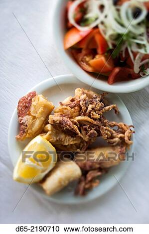 Stock Image - Greece, East Macedonia and Thrace Region, Kavala, Greek Salad with fried calamari.. Fotosearch