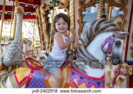Happy girl riding the merry go round. View Large Photo Image Stock Photo - Happy girl riding the merry go round.. Fotosearch