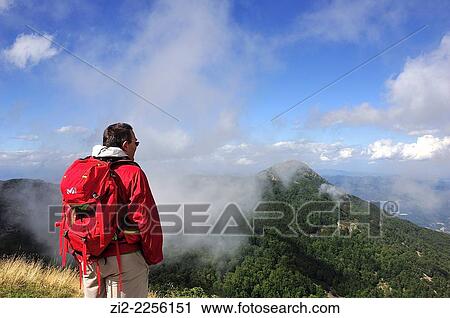 Stock Image - Hiker looking Les Agudes from Tur? del Home 1708 mts. Montseny Natural Park. Gerona, Spain. Fotosearch