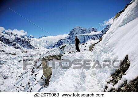 Stock Image - Hiker on Khumbu Glacier, Sagarmatha National Park, the Himalaya range, Khumbu area, Solukhumbu District, Sagarmatha Zone, Nepal. Fotosearch