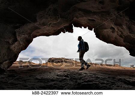 Stock Photo - Hiker outside cave in the northern Grampians. Victoria, Australia.. Fotosearch