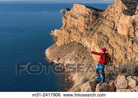 Hiker takes Gopro video over the Mediterranean sea from Sierra Helada natural park cliff, Benidorm, Alicante province, Spain. View Large Photo Image Stock Photograph - Hiker takes Gopro video over the Mediterranean sea from Sierra Helada natural park cliff, Benidorm, Alicante province, Spain.. Fotosearch