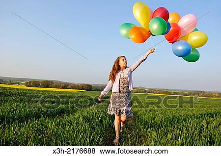 Stock Photo - little girl playing with balloons in the fields, Eure-et-Loir department, Centre region, France, Europe.. Fotosearch
