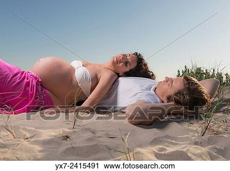 Stock Image - Man and pregnant woman at the beach. Tarifa, Costa de la Luz, Cadiz, Andalusia, Spain, Europe.. Fotosearch