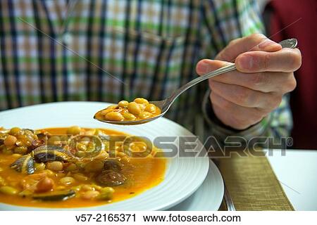Man having a spoonful of beans with seafood. Close view. View Large Photo Image Stock Image - Man having a spoonful of beans with seafood. Close view.. Fotosearch