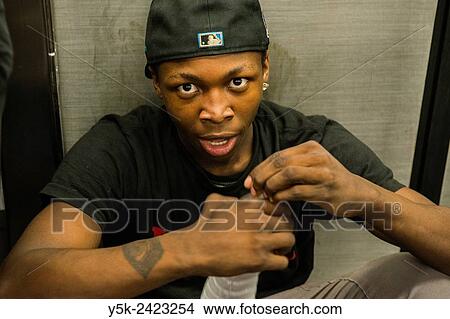 Picture - Manhattan, New York City, New York. African American male watching a show in a Brooklyn bound N Train.. Fotosearch