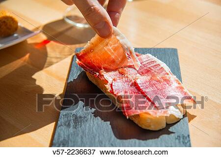 Man´s hand having Iberian ham in a bar. Close view. View Large Photo Image Stock Photo - Man´s hand having Iberian ham in a bar. Close view.. Fotosearch