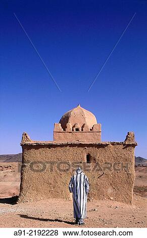 MOROCCO. SOUTH. OUARZAZATE. OLD MAN CLOSE TO AN ADOBE MARABOUT (MEANS A VAULTED HOLY MAN GRAVE SUBJECT TO PILGRIMAGES AND FAITH). View Large Photo Image Stock Photo - MOROCCO. SOUTH. OUARZAZATE. OLD MAN CLOSE TO AN ADOBE MARABOUT (MEANS A VAULTED HOLY MAN GRAVE SUBJECT TO PILGRIMAGES AND FAITH).. Fotosearch