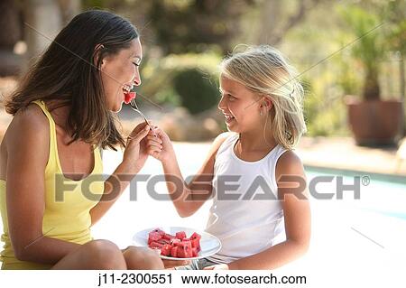 Mother and daughter, eating watermelon View Large Photo Image Stock Image - Mother and daughter, eating watermelon. Fotosearch