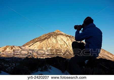 Photographer at sunrise in snow covered Teide National Park on Tenerife, Canary Islands, Spain. View Large Photo Image Stock Photo - Photographer at sunrise in snow covered Teide National Park on Tenerife, Canary Islands, Spain.. Fotosearch