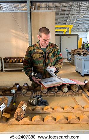 Poelkapelle, Belgium. Army Battalion for Demolition of Explosives. Army chief corporal working on the identification and classification of recovered live World War 1 shells and munition, prior to demolition. View Large Photo Image Stock Photo - Poelkapelle, Belgium. Army Battalion for Demolition of Explosives. Army chief corporal working on the identification and classification of recovered live World War 1 shells and munition, prior to demolition.. Fotosearch