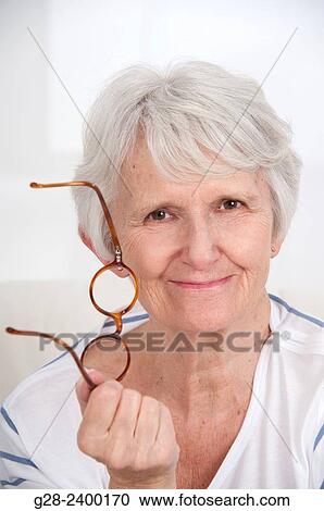 Portrait of beautiful senior woman holding glasses View Large Photo Image Stock Image - Portrait of beautiful senior woman holding glasses. Fotosearch