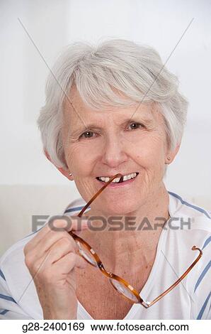 Portrait of beautiful senior woman holding glasses View Large Photo Image Stock Photo - Portrait of beautiful senior woman holding glasses. Fotosearch