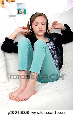 pretty little girl listening to music with a headset and stopping her ears with her fingers for concentration View Large Photo Image Stock Photo - pretty little girl listening to music with a headset and stopping her ears with her fingers for concentration. Fotosearch