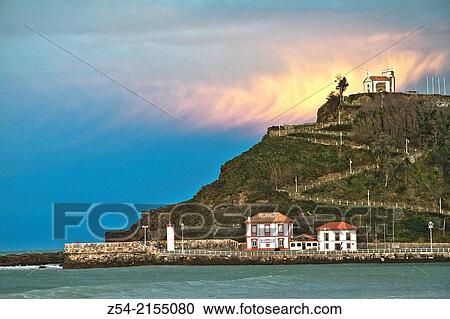 Stock Image - Ribadesella harbor entance and La Virgen de la Guia hermitage, Asturias, Spain.. Fotosearch