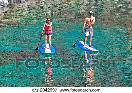 Riding the Standup Paddle Board at Blue Heart Spring in the Snake River Canyon near the city of Hagerman in southern Idaho. View Large Photo Image Stock Photo - Riding the Standup Paddle Board at Blue Heart Spring in the Snake River Canyon near the city of Hagerman in southern Idaho.. Fotosearch