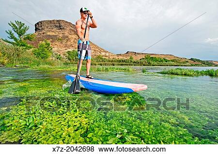 Riding the Standup Paddle Board at Box Canyon on the Snake River in the Snake River Canyon near the city of Hagerman in southern Idaho. View Large Photo Image Stock Photo - Riding the Standup Paddle Board at Box Canyon on the Snake River in the Snake River Canyon near the city of Hagerman in southern Idaho.. Fotosearch