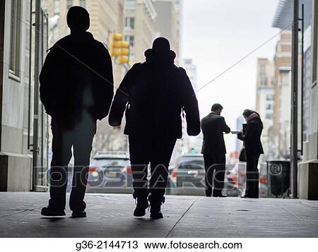 Stock Image - Silhouette of pedestrian and city buildings in Philadelphia, Pennsylvania, United States.. Fotosearch
