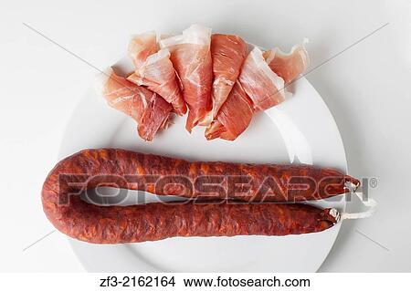 Spanish ham and a chorizo sausage on a white plate. View Large Photo Image Picture - Spanish ham and a chorizo sausage on a white plate.. Fotosearch