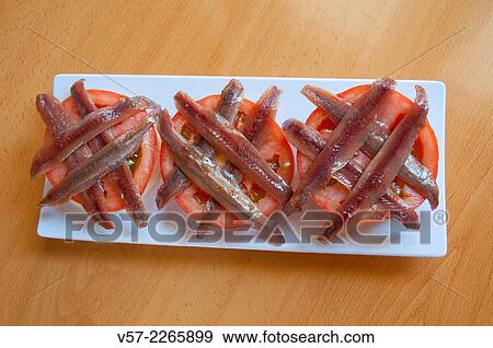 Stock Photo - Spanish tapa: anchovy fillets on sliced tomato.. Fotosearch