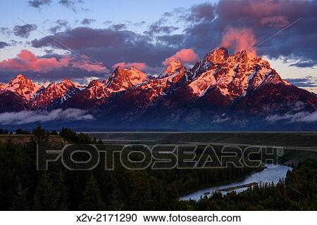 Stock Image - Sunrise on the Grand Teton Mountains from the Snake River Overlook.. Fotosearch