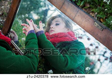 Stock Photo - The girl in the mirror. Inspiration Alice in Wonderland. Reflection.. Fotosearch