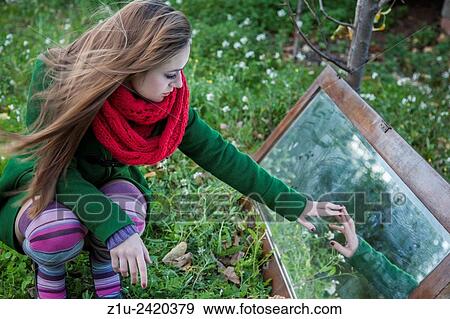 Stock Photo - The girl in the mirror. Inspiration Alice in Wonderland.. Fotosearch