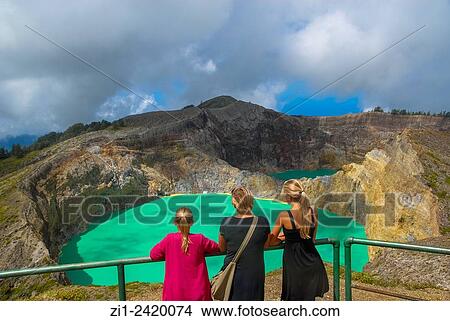 tourists at colourful volcanic lake of kelimutu volcano at flores indonesia View Large Photo Image Picture - tourists at colourful volcanic lake of kelimutu volcano at flores indonesia. Fotosearch