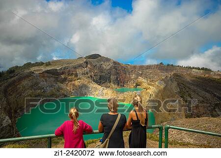 Stock Image - tourists at colourful volcanic lake of kelimutu volcano at flores indonesia. Fotosearch